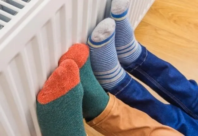 adult and child feet against a radiator with colourful socks